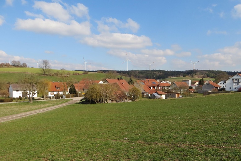 Die BEG hat diese – nach eigenen Angaben seriöse und technisch realistische – Fotosimulation veröffentlicht. Sie zeigt den Blick vom Ortseingang Streitdorf auf fünf Windräder im Förnbacher Forst. „Die Anlagen sind auf der Simulation zwar topographisch realistisch, aber nicht enggültig angeordnet“, wird dazu erklärt. Eine konkrete Platzierung auf einem bestimmten Grundstück lasse sich daraus nicht ableiten. „Am Ende können sich die Standorte noch wesentlich verändern, vor allem dann, wenn man Anlagen heraus- oder dazunehmen würde“, so die BEG. Das Windrad ganz links hinten im Bild ist die bestehende Anlage im Lustholz. Quelle: BEG