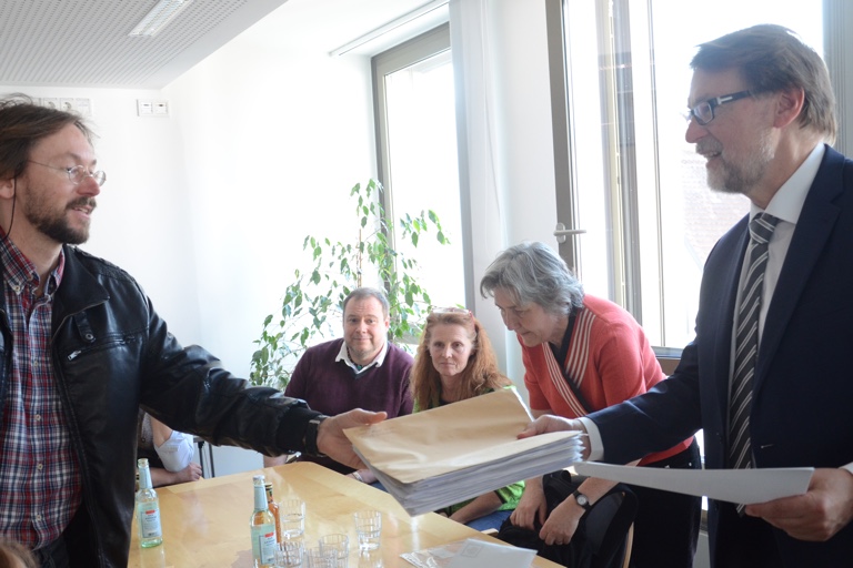 Landrat Martin Wolf (rechts) nimmt einen Stapel von Einwendungen entgegen. Fotos: Zell