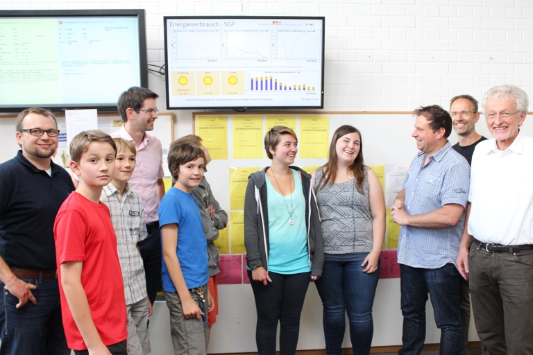 Freuen sich über die gelungene Realisierung der Energie-Anzeige in der Aula des Schyren-Gymnasiums (von links): Haustechniker Markus Turger und Lehrer Bernhard Laux mit den Schülern der Forscherklasse Sebastian Paul, Ferdinand Jany, Severin Leder und Laurin Reimann; die beiden Jugendparlamentarierinnen Stefanie Reisner und Elisabeth Denk, Michael Herschmann vom Energie- und Solarverein, Informatiklehrer Ingo Bartling und der stellvertretende Schulleiter Hans Kern.