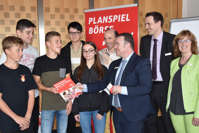 Übergabe der Spielunterlagen für das 37. "Planspiel Börse" an einige Teilnehmer der Georg-Hipp-Realschule Pfaffenhofen mit ihrem Lehrer Manfred Hoheneder (Vierter von rechts) durch Helmut Müller (Dritter von rechts), Abteilungs-Leiter in Sachen Vermögens-Management bei der Sparkasse Pfaffenhofen. Mit auf dem Bild auch Vertriebs-Direktor Martin Behrens von der Deka-Bank (Zweite von rechts) und Birgit Distler (rechts), die Marketing-Leiterin der Pfaffenhofener Sparkasse.