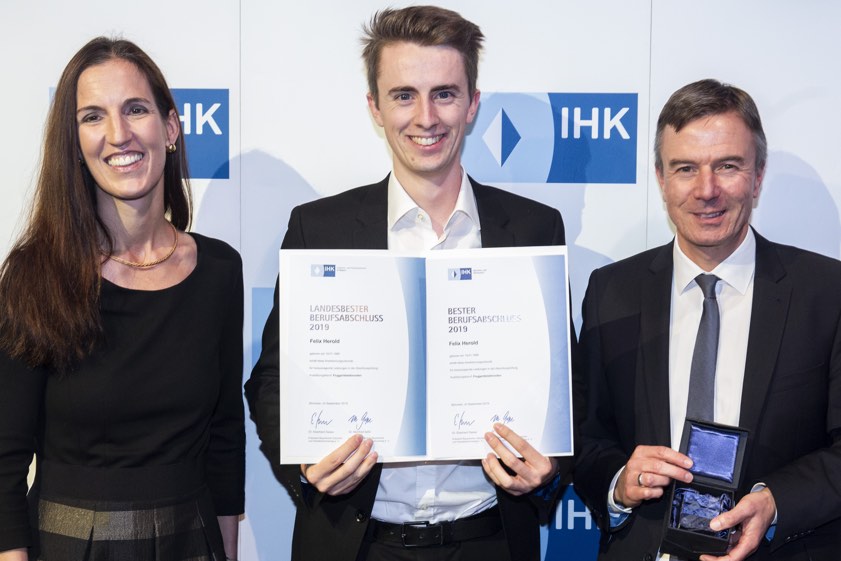 Bei der Feierstunde der IHK für München und Oberbayern: IHK-Vizepräsidentin Kathrin Wickenhäuser-Egger und Thomas Kürn (rechts), Mitglied der Hauptgeschäftsführung und Bereichsleiter in Sachen Berufsbildung bei der IHK für München und Oberbayern, beglückwünschen Felix Herold. Foto: IHK für München und Oberbayern / Goran Gajanin