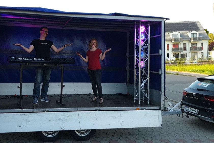 "Ihr dürft nicht zu uns kommen – dann kommen wir einfach zu Euch!": Mit diesem musikalisch aufgerüsteten Anhänger bieten Sängerin Cathy Smith und Pianist Michael Herrmann ab sofort musikalische Hausbesuche an – die Garten-Zaun-Gigs.