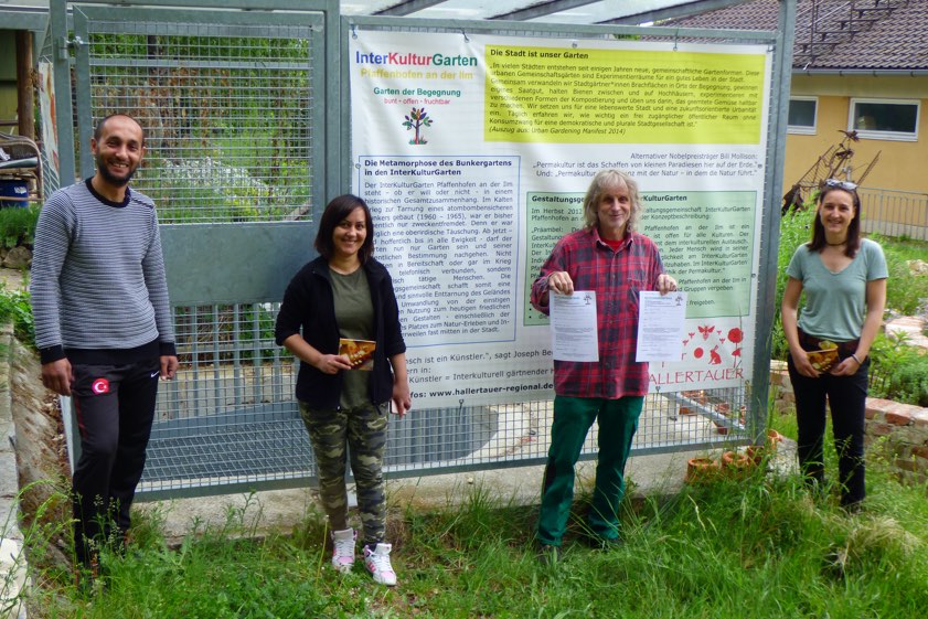 Koordinator Manfred "Mensch" Mayer (Zweiter von rechts) überreichte die Nutzungs-Verträge für den Inter-Kultur-Garten an die neuen Mitglieder: Resmir und Redzeb sowie Diana.