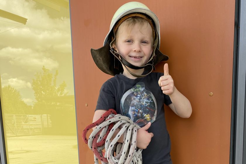 Vorschulkind Fabian aus der Kita "Burzlbaam" freut sich über das echte Feuerwehr-Equipment.