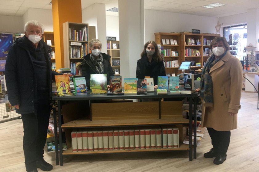 Sarah Haberhauer (hinten, rechts) von der Buchhandlung "WortReich", Anne Bienlein von der "Tafel" in Pfaffenhofen (hinten, links) sowie Christa Kuhn und Hans Kern (vorne) vom Verein zur Förderung der Pfaffenhofener "Tafel" in der Buchhandlung mit einer Auswahl der möglichen Bücher.
