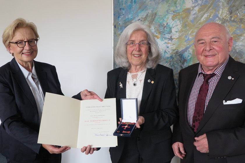 Regierungs-Präsidentin Maria Els (links) händigte Helga Inderwies das Verdienstkreuz am Bande aus. Rechts Ehemann Hellmuth Inderwies. Foto: Regierung von Oberbayern