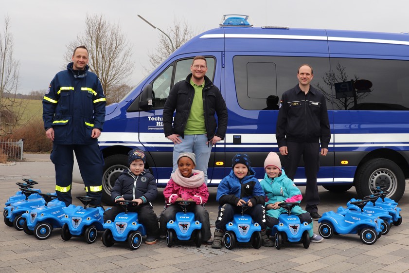 Michael Matthes (von links), Daniel Riegel und Alexander Müller bei der Übergabe der Bobby-Cars. Philipp, Takiya, Luka und Charlotte durften die Gefährte gleich testen.