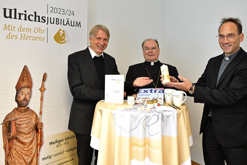 Von links: Domkapitular Thomas Groll, Bischof Bertram Meier und Pfarrer Christoph Hänsler bei der Übergabe des Starter-Pakets zum Ulrichs-Jubiläum Foto: Schnall, pba