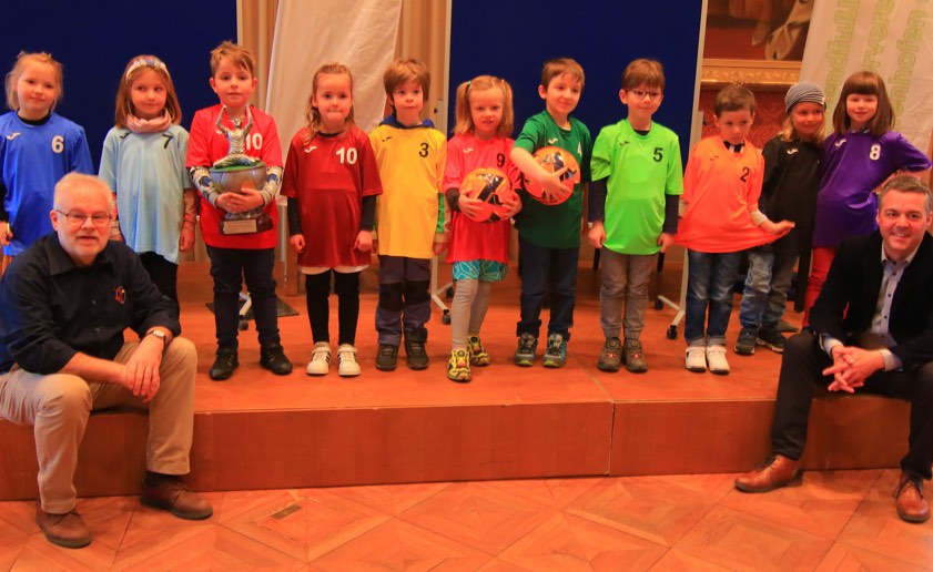 Robert Schröder vom Jugendfußball-Förderverein (links) und Bürgermeister Thomas Herker mit Kindern aus den Pfaffenhofener Kitas in ihren jeweiligen Trikots. Foto: Ralph Steffen