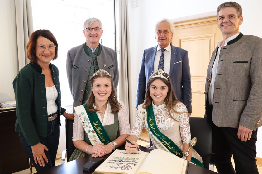Hopfenkönigin Eva-Maria Pichlmeyer (vorne, rechts) und Vize-Hopfenkönigin Anna Fischer trugen sich ins Goldene Buch des Landkreises Freising ein. Mit dabei waren Rudelzhausens Bürgermeister Michael Krumbucher (hinten, von rechts), Landrat Helmut Petz, Hörgertshausens Bürgermeister Michael Hobmaier und dessen Stellvertreterin Elisabeth Piterna. Foto: Landratsamt Freising